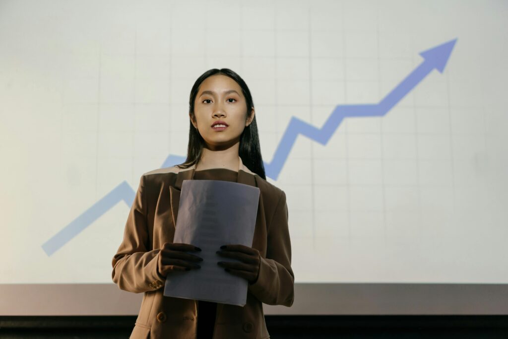 a woman standing in front of a stage with an arrow up symbolizing growth showing in the background