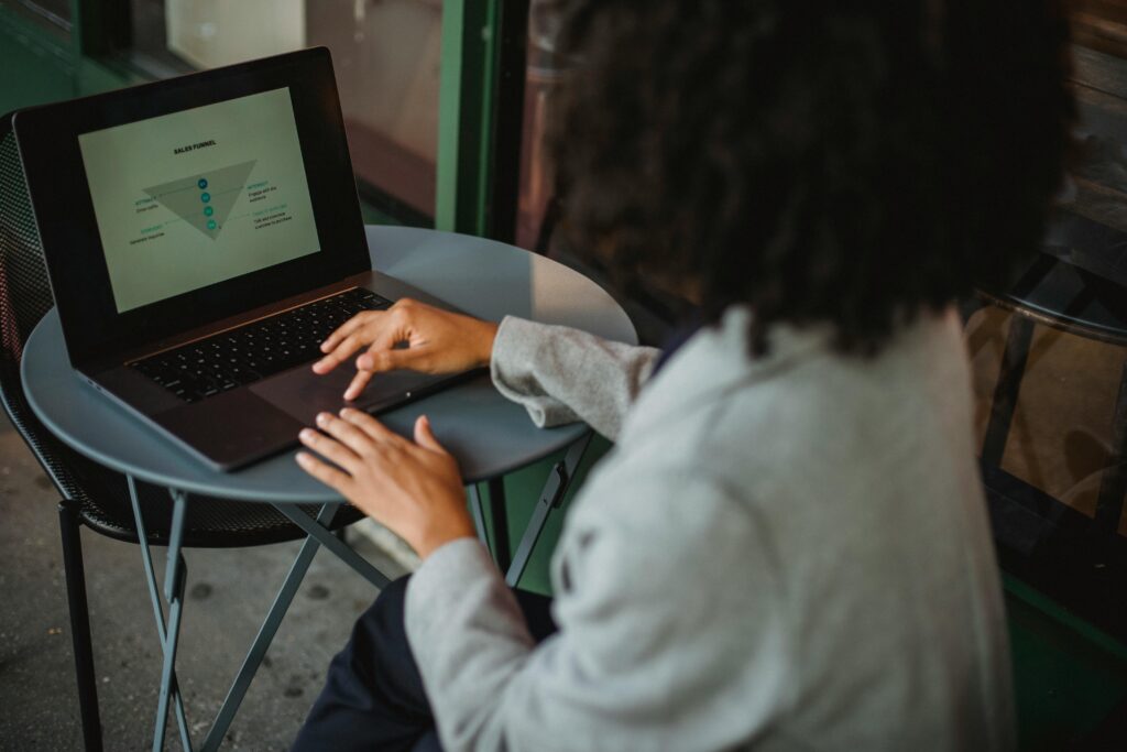 A woman sitting on a chair and typing on her laptop