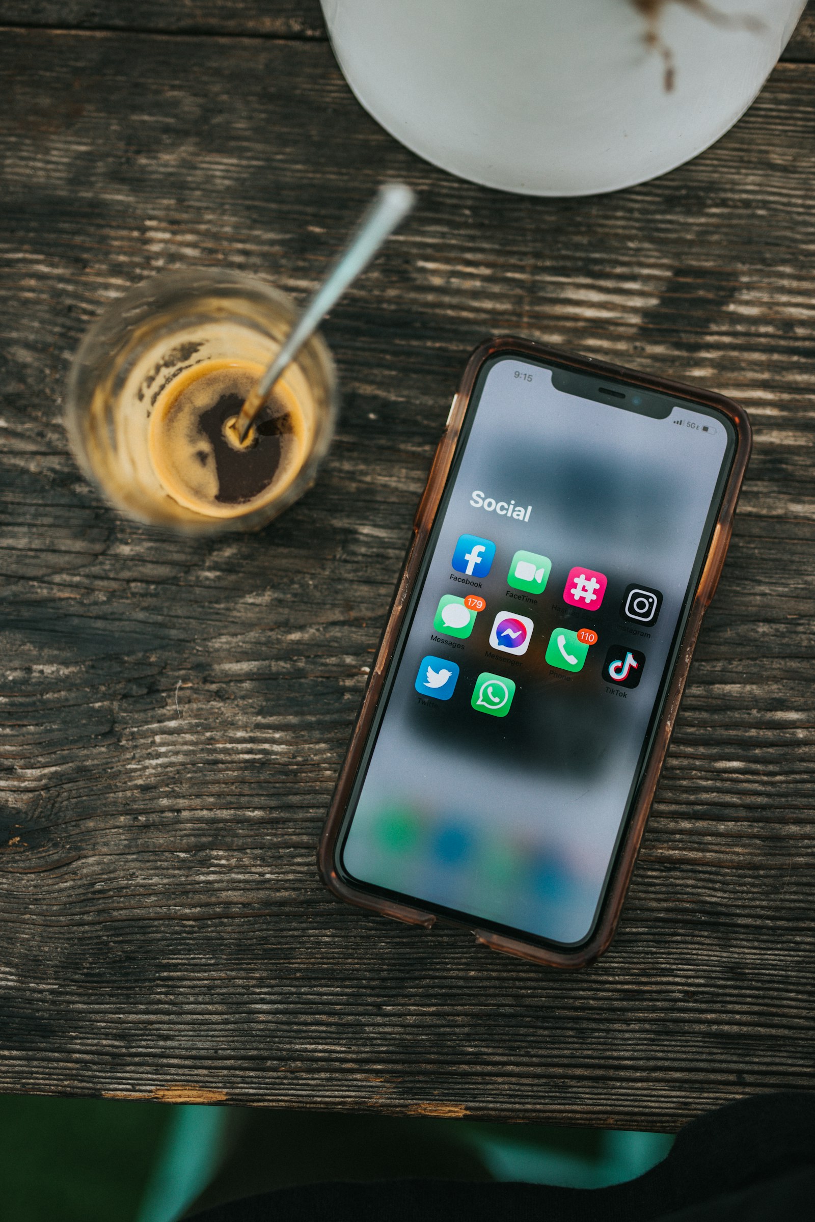 Smartphone showing social media apps next to a coffee